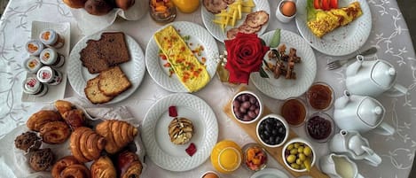 Ein reichhaltiges Frühstücksbuffet mit verschiedenen Speisen, darunter Gebäck, Früchte und Getränke.