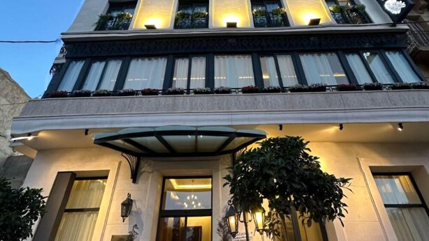 A tall hotel with multiple floors, large windows, and a sign indicating it is a hotel. - Le Palme Hotel Oran (Oran)