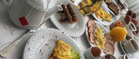 Una mesa de desayuno con diferentes platos, como huevos, tostadas y fruta.