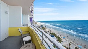Un balcon avec vue sur une plage et l’océan.