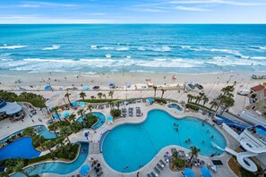 A resort with a large pool area, a beach, and ocean views.