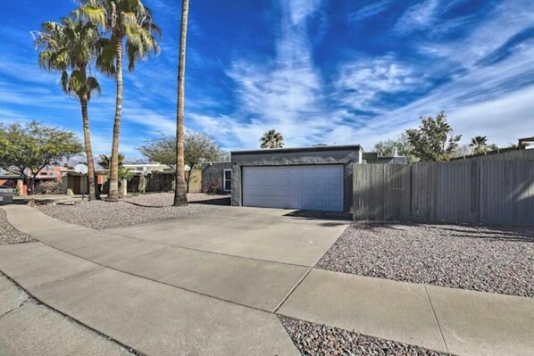 A residential property with a paved driveway, a garage, and a wooden fence. - Boho-off-Broadway, fun and chic family home!
(Tucson)