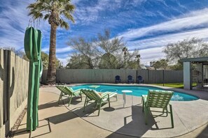A backyard with a swimming pool, green lounge chairs, and a palm tree. - Boho-off-Broadway, fun and chic family home!
(Tucson)