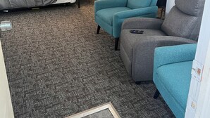 A compact living space with a bed, two sofas, a small table, and a wall decoration. - Stay in Paradise! Motel in Walleye Capital & close to Lake Erie Island ferries. (Port Clinton)