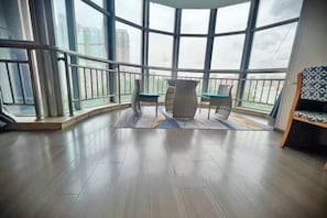 A balcony with a view of buildings, a table with chairs, and a patterned rug. - Eaka Hotel (Shijiazhuang Guanghua Road) (Shijiazhuang)