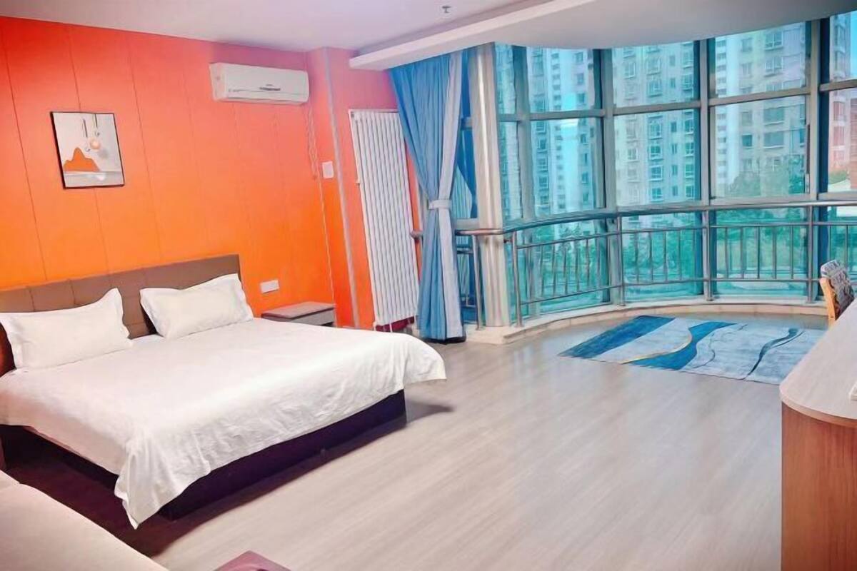 Een hotelkamer met een groot bed, een raam met uitzicht op wolkenkrabbers, en een modern design.