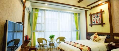 Una habitación de hotel con cama, televisión, escritorio y una silla.