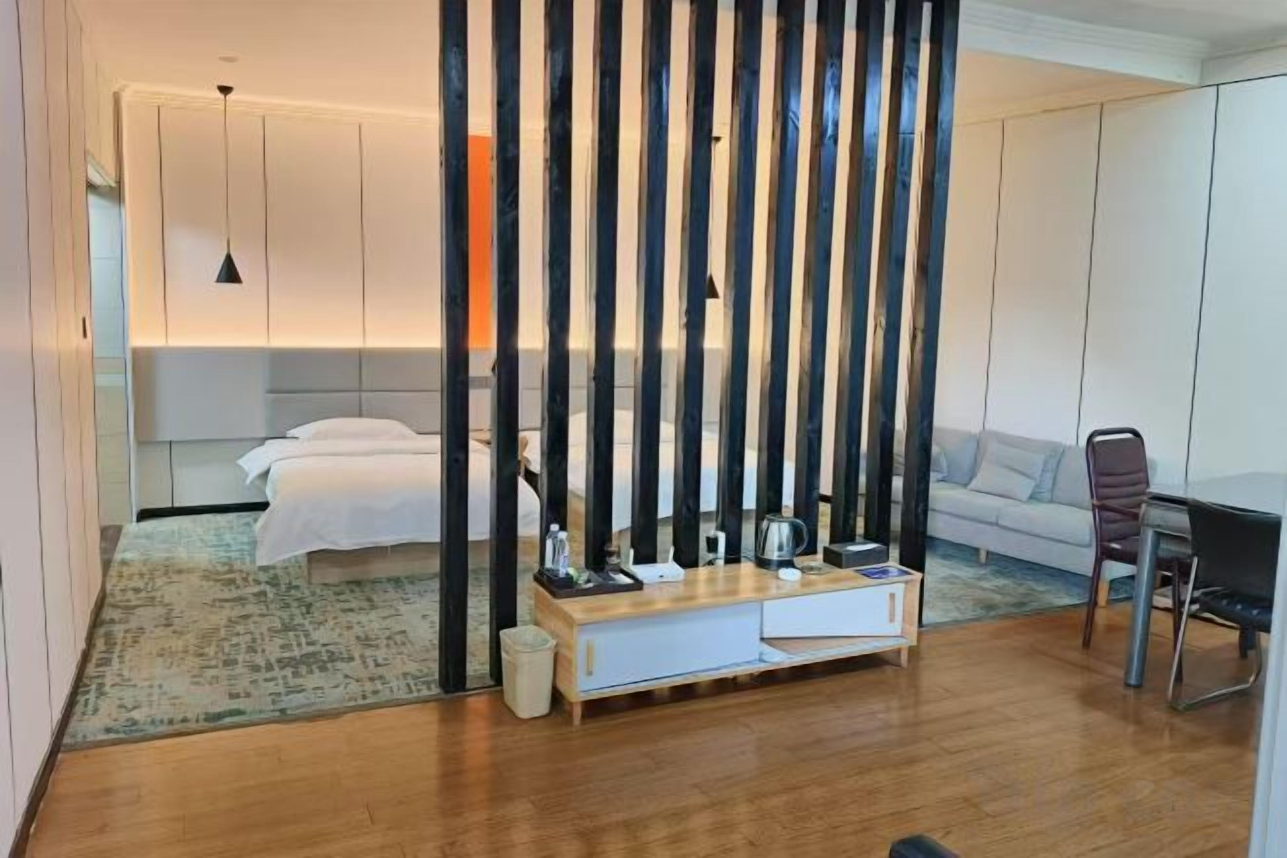 A modern hotel room with a bed, bedside table, and a view of the city.
