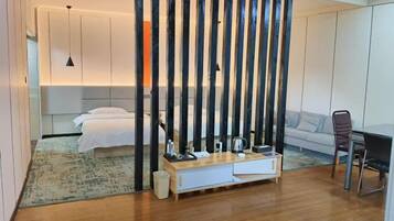 A modern hotel room with a bed, bedside table, and a view of the city.