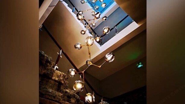 Un intérieur moderne doté d’un plafond original, avec des luminaires sphériques et une verrière.