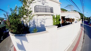 Un edificio blanco con balcón y un cartel que dice "Villa di Mani".