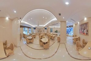 A spacious hotel lobby with multiple seating areas, a central chandelier, and a view of the dining area. - Vienna International Hotel (Wanzhou Gaosuntang Pedestrian Street Branch) (Chongqing)