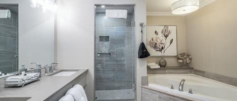 Ein modernes Badezimmer mit großem Spiegel, zwei Waschbecken, einer Dusche und einer Badewanne.