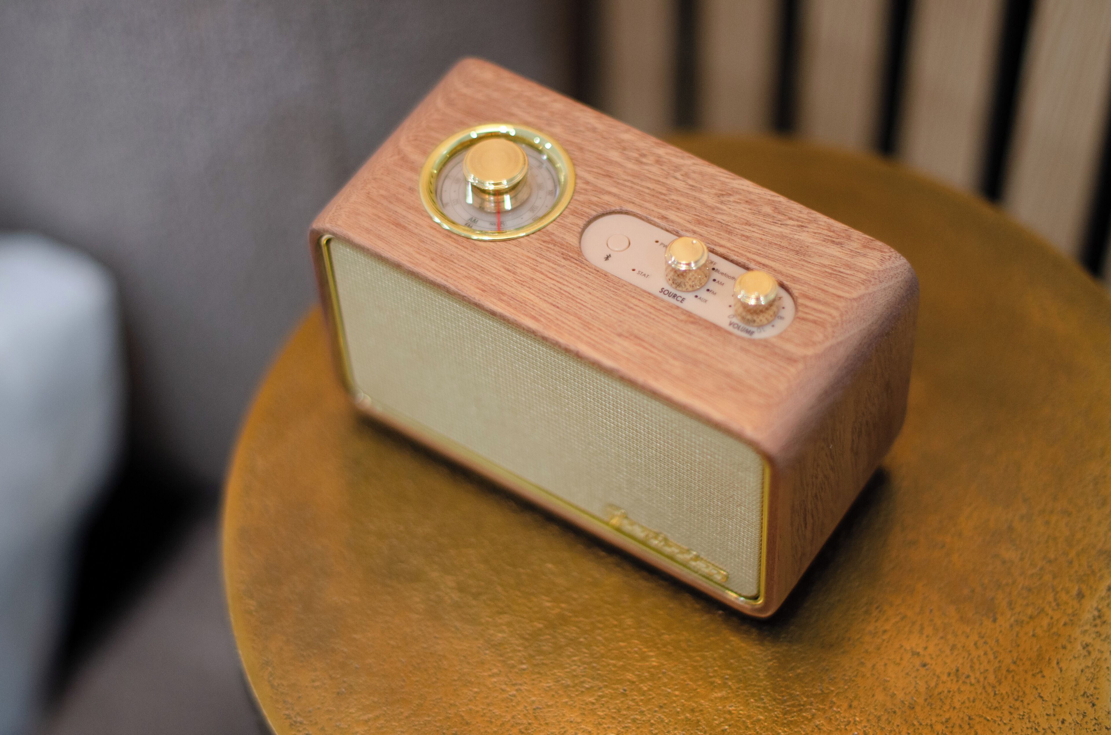 Une vieille radio posée sur une table ronde en bois.