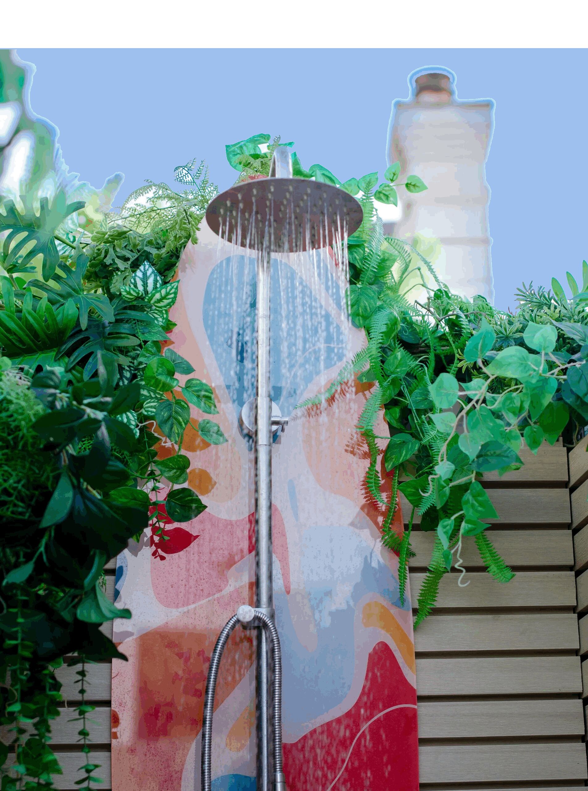 A colorful showerhead with water flowing, surrounded by lush green plants.