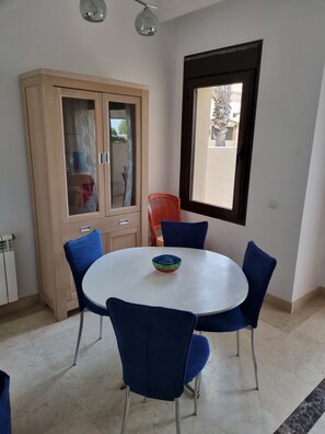 Enjoy meals in this cozy dining area with a round table and four chairs, a cabinet, and a window.