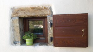 Una porta con cornice in pietra e un vaso con una pianta verde accanto.