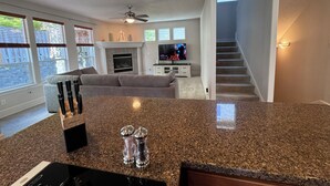 A modern living room with a fireplace, a television, and a staircase leading to an upper level. - Spacious 5 Bedrooms, 7 beds - Sleeps Large Groups (Portland)
