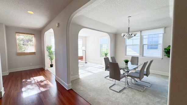 A spacious living area with hardwood flooring, a glass dining table, and modern chairs. - Spacious 5 Bedrooms, 7 beds - Sleeps Large Groups (Portland)