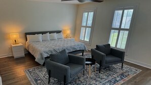 A bedroom with a bed, two nightstands, two lamps, a ceiling fan, and a patterned rug. - Spacious 3BR 3BA above Brewery, Pizza Shop & Arcade 5 mins to DT Indy (Indianapolis)