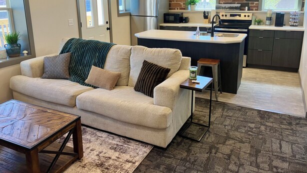 A modern kitchen with a central island, a built-in oven, and a stainless steel refrigerator. - 2 Bedroom Apartment - Downtown (Marshall)