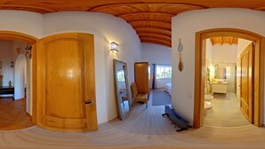 Un hall d’entrée spacieux, doté de portes en bois, d’un banc et d’un miroir.