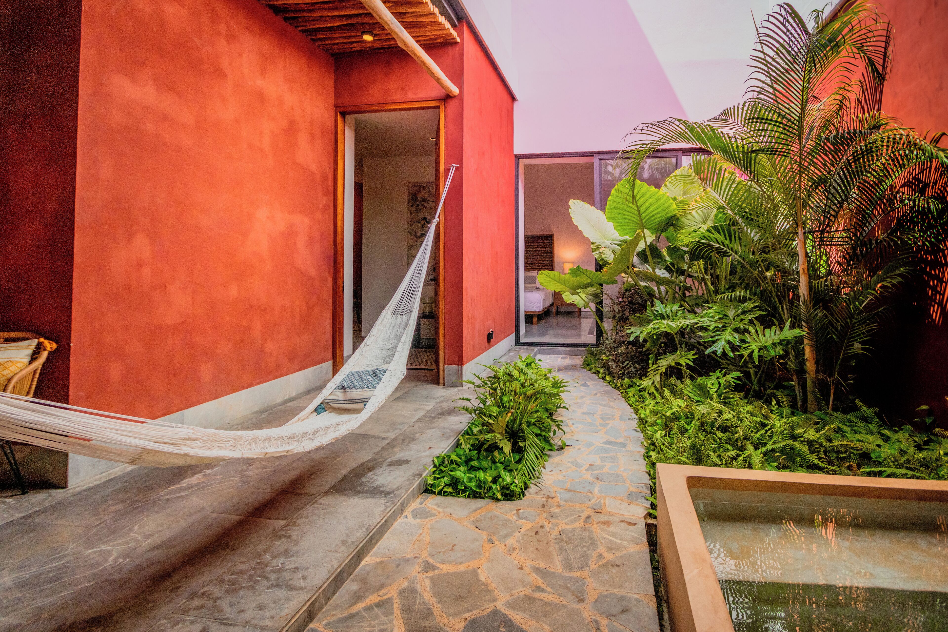 A hammock, a water feature, and a lush garden area in a modern building's courtyard.