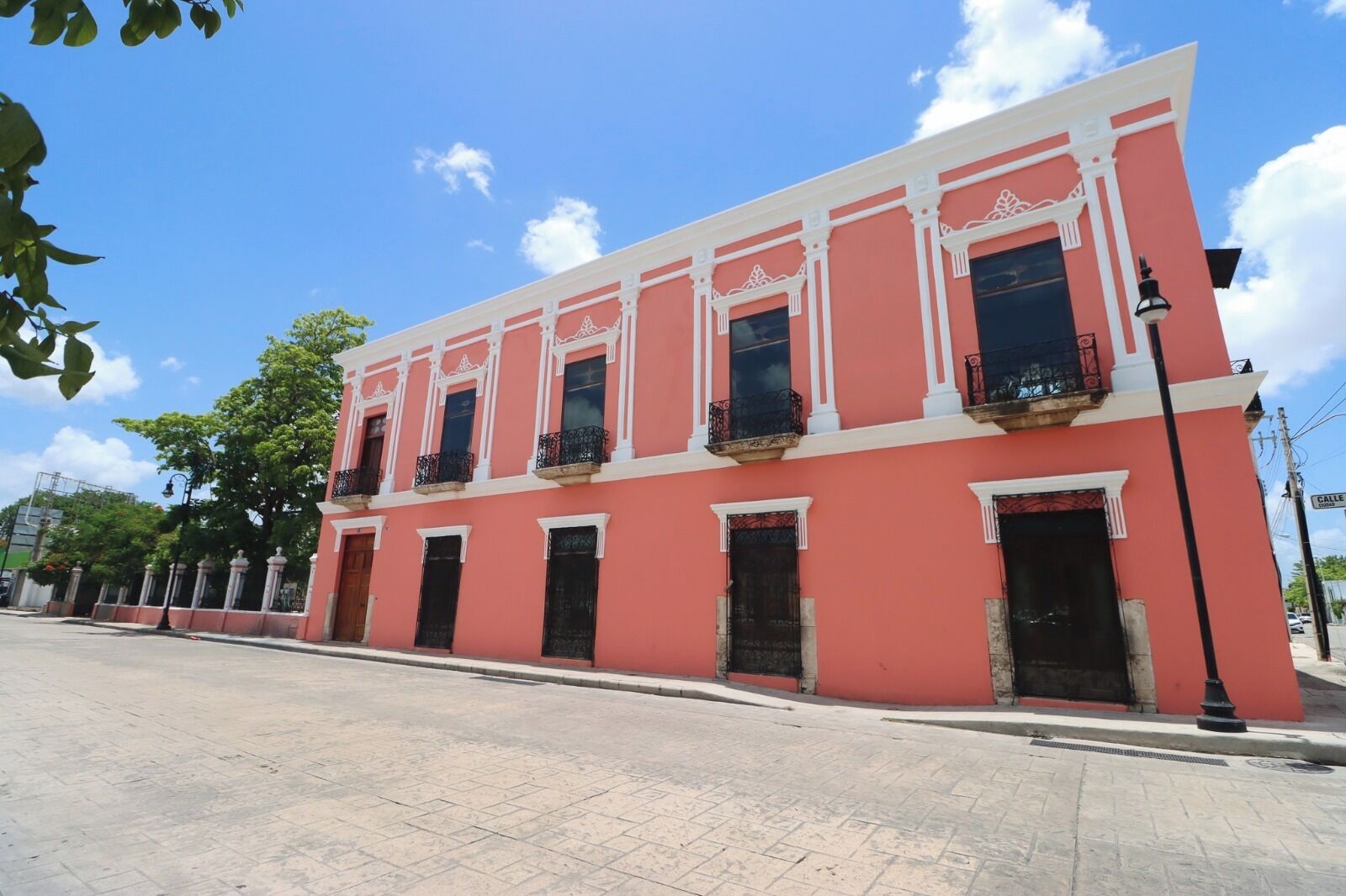 Un bâtiment rose avec des ornements blancs et des balcons noirs.