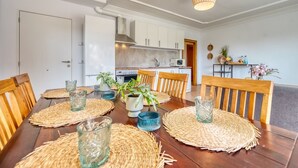 A dining area with a wooden table, woven placemats, and glassware.