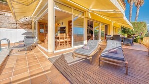 A sunlit outdoor deck with lounge chairs, a bar area, and a view of the sea. - Villa "Costacabana - Santa Cristina" with Sea View, Only Families (Blanes)