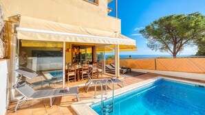A poolside area with a covered seating area, a pool, and a view of the sea. - Villa "Costacabana - Santa Cristina" with Sea View, Only Families (Blanes)