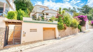 A residential building with a gated entrance, stone steps, and a garage door. - Villa "Costacabana -  Cleo" with Sea View, Private Pool & Wi-Fi (lloret de mar)
