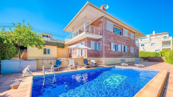 Un bâtiment à deux étages doté d’une piscine, d’un espace extérieur aménagé et d’une antenne parabolique.