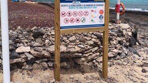 A beach sign with safety instructions and a lifebuoy. - Vacation Studio 'Loft La Caletilla' with Sea View and Private Terrace (Caleta de Sebo)