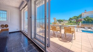 A balcony with a pool, wicker furniture, and a view of the surrounding area. - Villa "Costacabana - Abigail" with Sea View, Private Pool & Wi-Fi (Lloret De Mar)