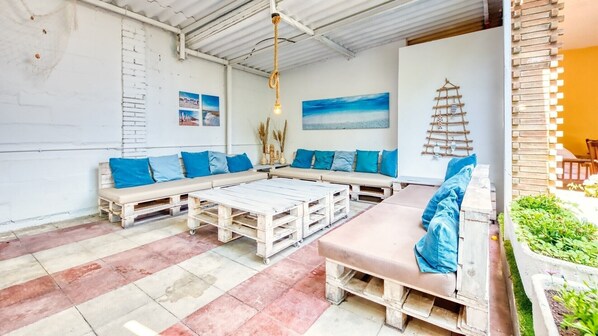 Un espace extérieur aménagé dans un style rustique, avec des bancs en bois et une table basse.
