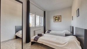 A hotel room with a large mirror, two beds, a radiator, and a window. - Villa "Costacabana - Abigail" with Sea View, Private Pool & Wi-Fi (Lloret De Mar)