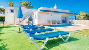 A modern house with a swimming pool, outdoor seating, and a covered patio area. - Villa "Costacabana - Yara" with Private Pool & Wi-Fi (Lloret De Mar)