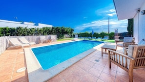 A swimming pool with lounge chairs and a patio area.