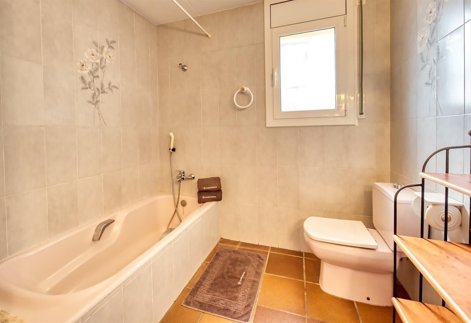 Un baño con bañera, inodoro y ventana.