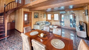 Interior de madera con comedor, escalera y sala de estar.