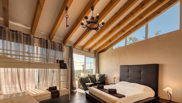 Un dormitorio moderno con una cama grande, un escritorio, una silla y una araña.