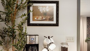 Ein Holztischchen mit Kaffeemaschine, Tassenhalter und einer Kaffeedose.