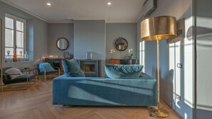 A modern living room with a sofa, chairs, a fireplace, and a floor lamp. - Apartments Florence - Repubblica Exclusive with Balcony (Florence)