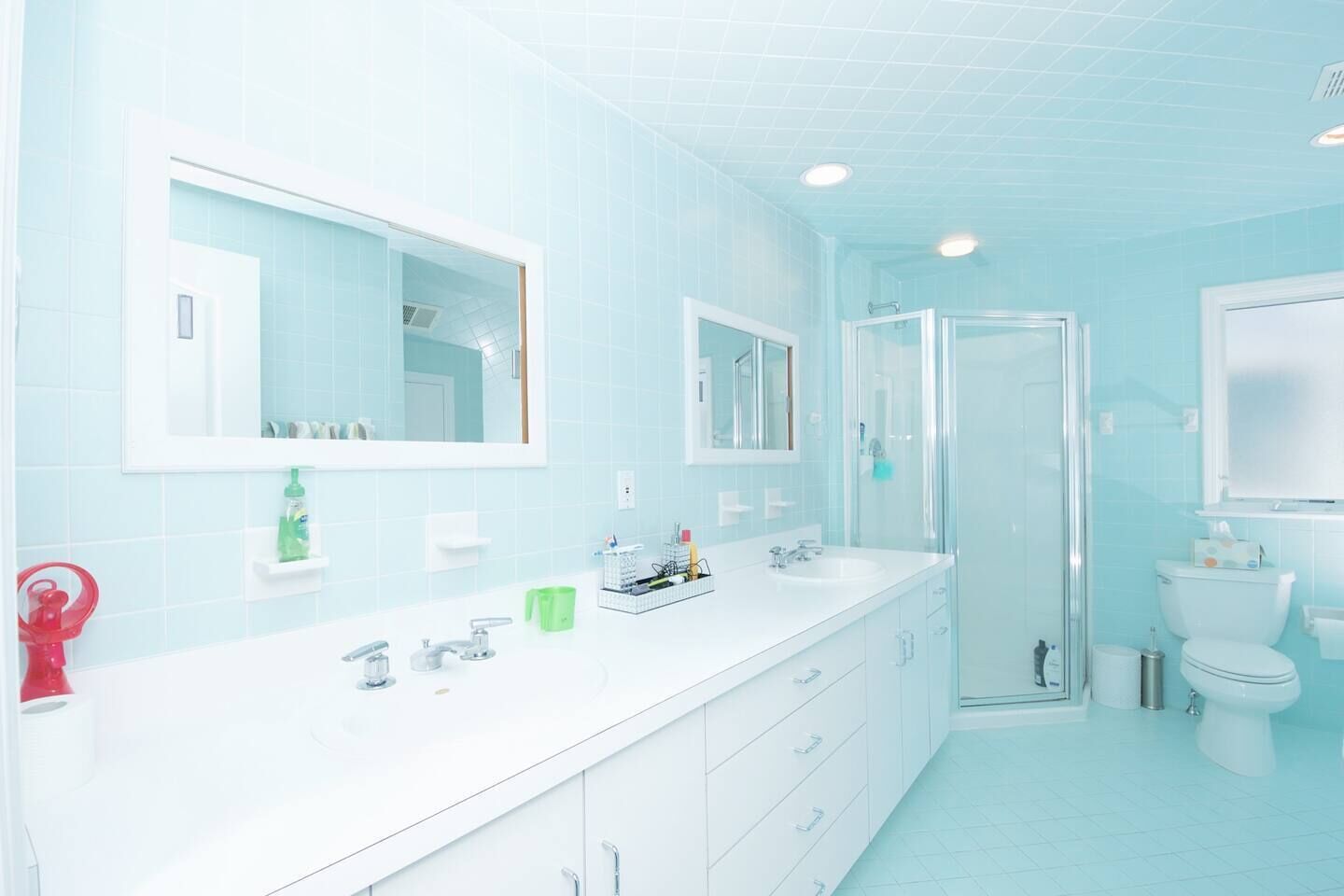 Ein modernes Badezimmer mit einem weißen Waschtisch, einer Duschkabine aus Glas und einer Toilette.