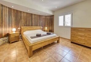 Une chambre à coucher avec un lit en bois, des tables de chevet, une commode et une fenêtre.