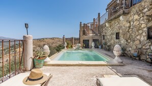 A stone building with a swimming pool, outdoor seating, and a view of the landscape. - Holiday Home 'Ermita De Las Eras' with Mountain Views, Wi-Fi and Air Conditioning (Algarinejo)