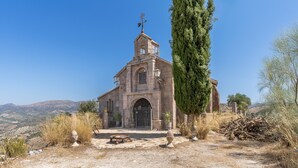 A stone church with a bell tower, arched entrance, and a clear view of the surrounding landscape. - Holiday Home 'Ermita De Las Eras' with Mountain Views, Wi-Fi and Air Conditioning (Algarinejo)