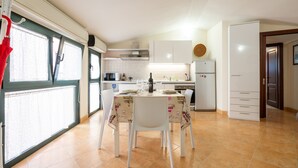 Una cucina con tavolo, sedie e frigorifero.