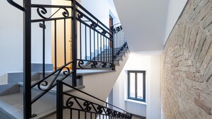 Una scala con ringhiere nere, un muro in mattoni e una finestra.